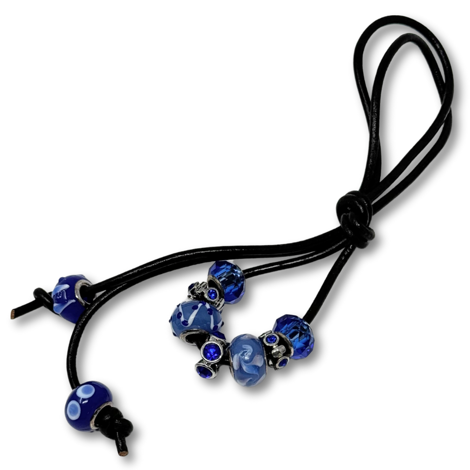 A black hair tie with blue beads integrated into its design, featuring a knot at the top and additional decorative beads.